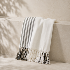 black and white towel leaning against a cream wall