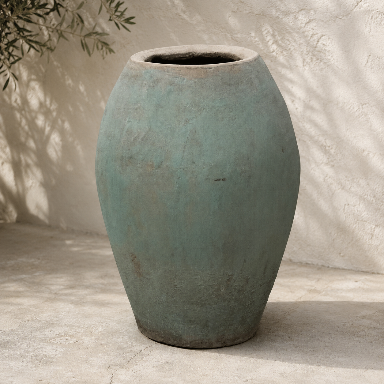 Large textured blue-green ceramic vase on a neutral background