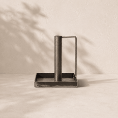 Metal  Forged candlestick with handle and tray on a beige surface with shadow effect