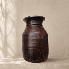 Brown wooden Artisanal  vase on a beige surface with a neutral background