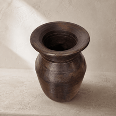 Dark brown wooden vase on a light beige background
