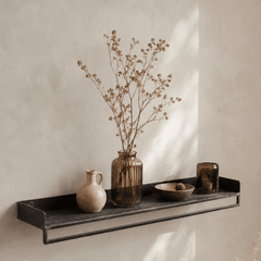 Decorative metal shelf with vases and a bowl against a beige wall
