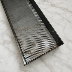 Perforated iron shelf on a marble counter 
