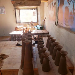 Clay pottery pieces on a table in a workshop setting