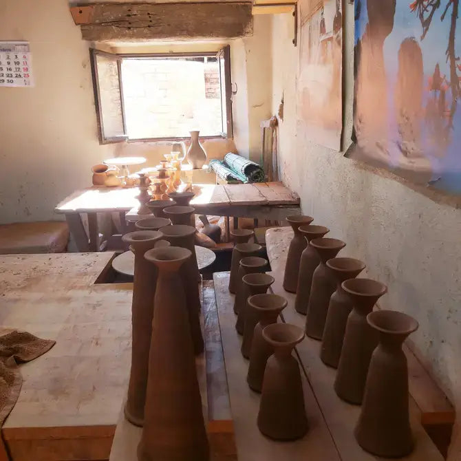 Clay pottery pieces on a table in a workshop setting