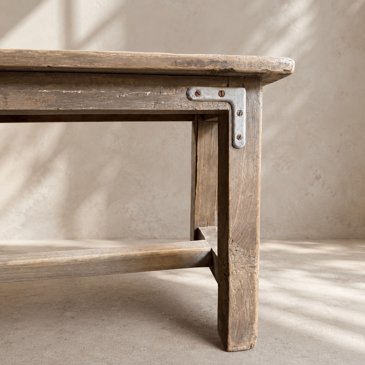 Wooden bench with metal bracket against a neutral background