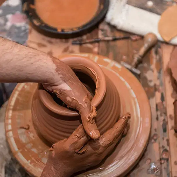 Person working with clay on a potter's wheel