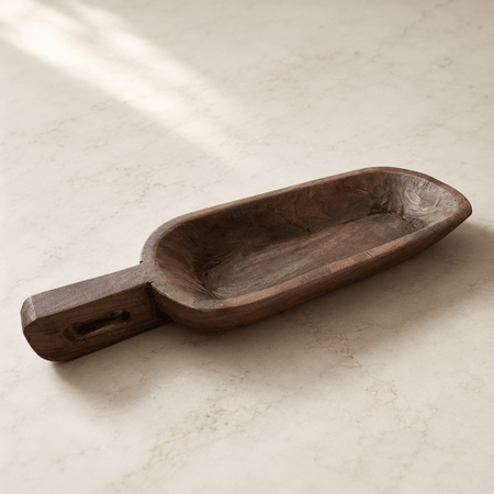 Wooden scoop on a light beige surface