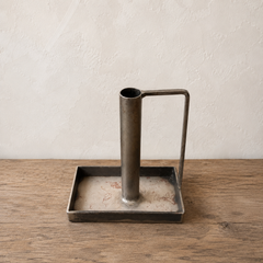 metal candle with stick rectangular  base on a wooden surface