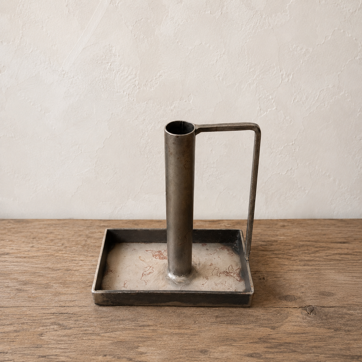 metal candle with stick rectangular  base on a wooden surface