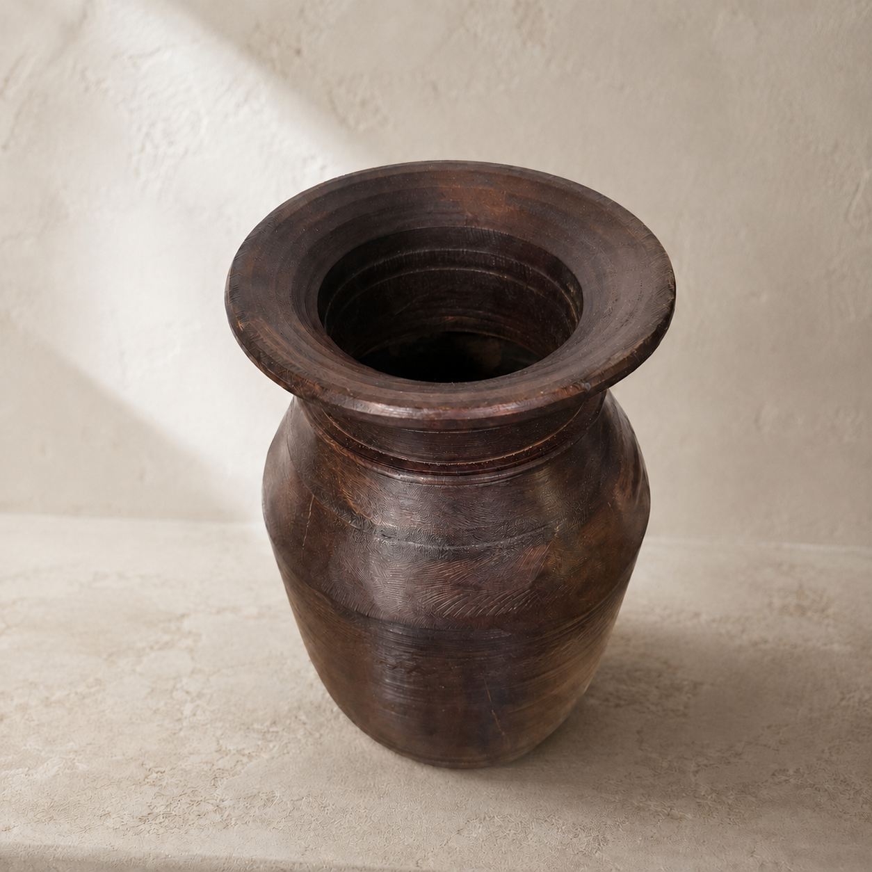 Wooden vase on a textured beige surface