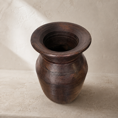 Wooden vase on a textured beige surface