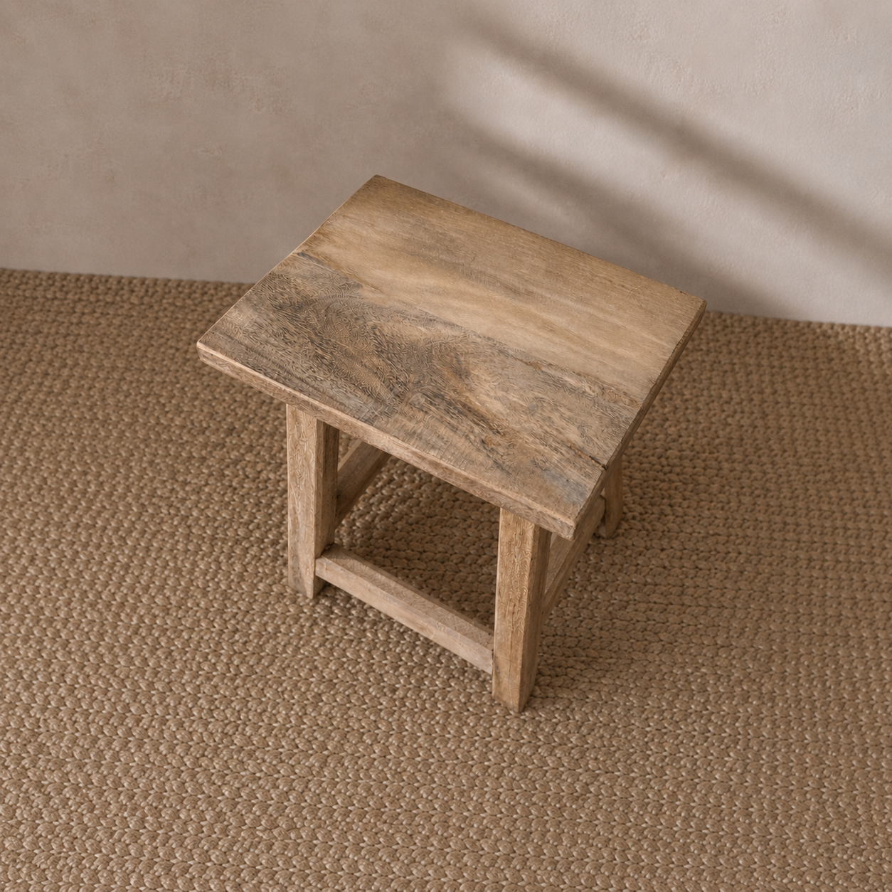 Wooden stool on a textured brown floor with a neutral wall background