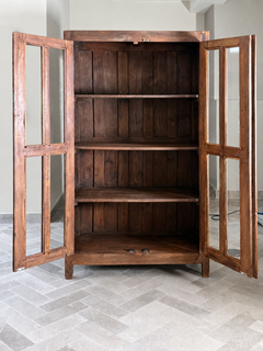 Wooden cabinet with glass doors on a tiled floor