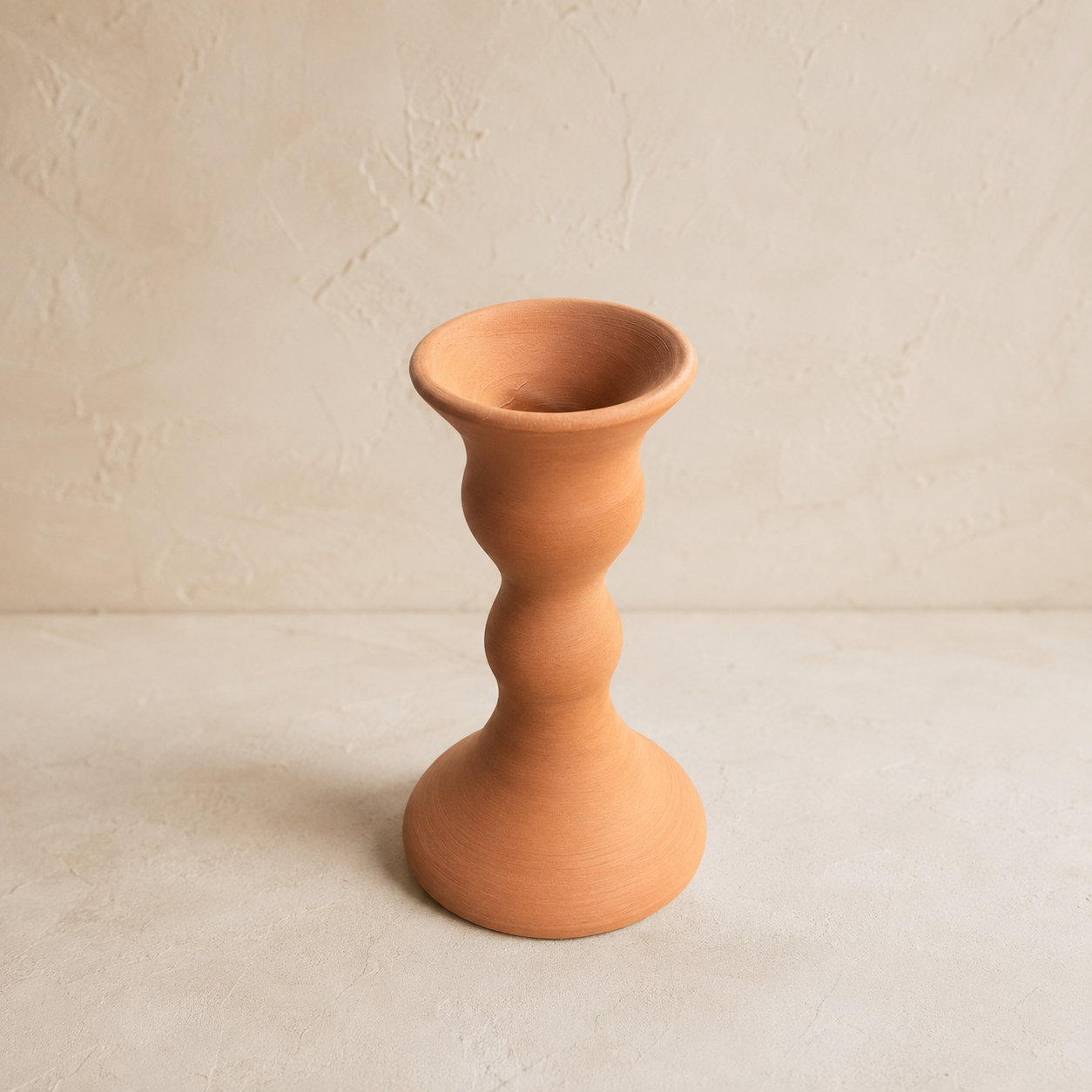 Terracotta candle holder on a neutral background