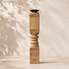 Wooden column with decorative carvings on a neutral background